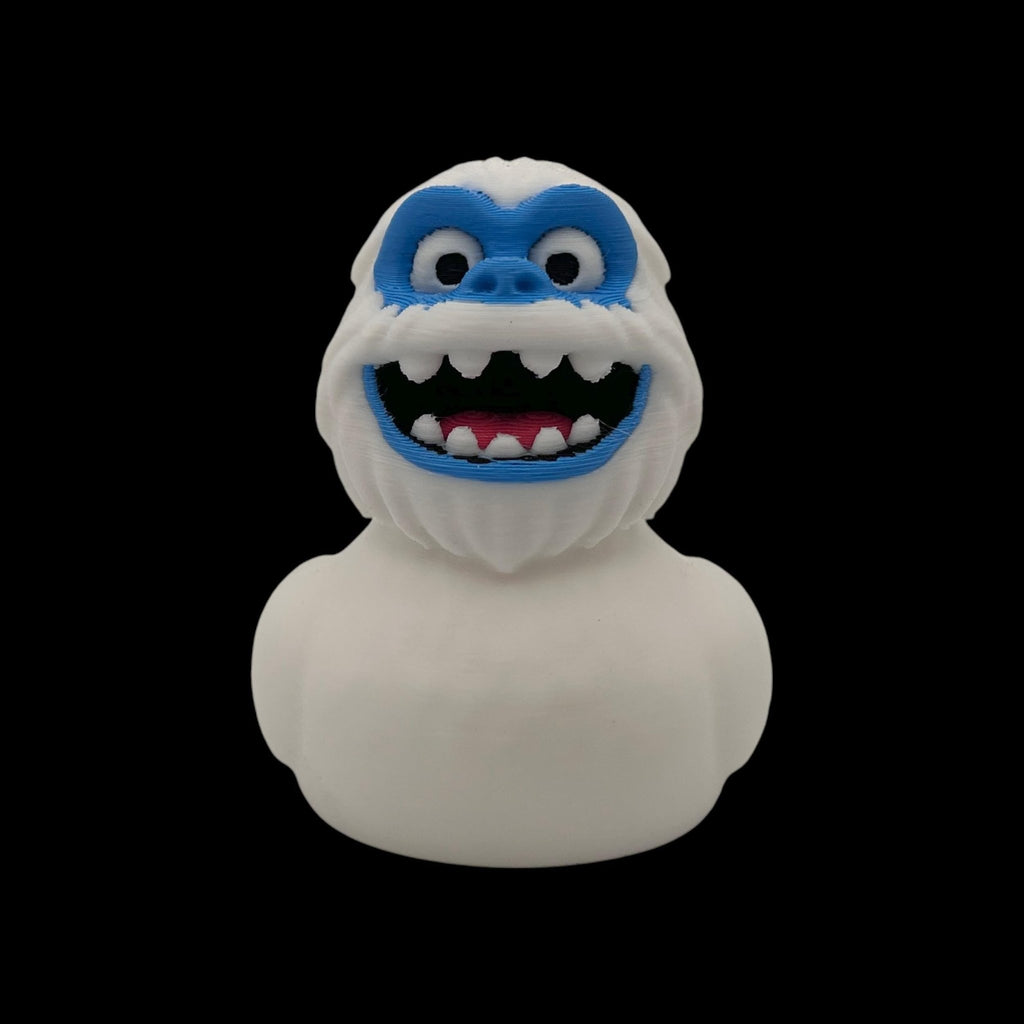 White 3D printed Yeti duck shown from the front and rear-side angles, with its curved tail visible.