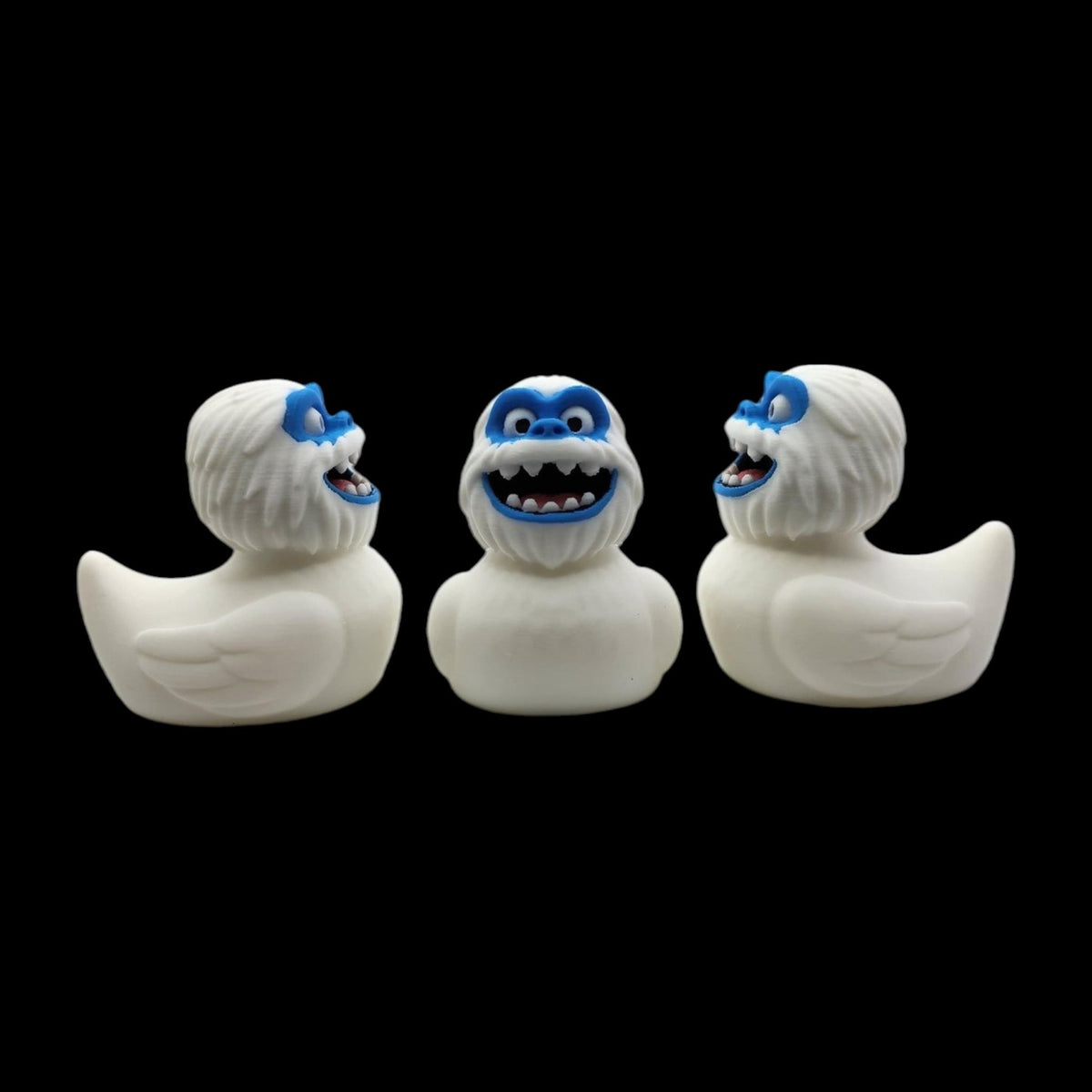 Three views of a white 3D printed Yeti duck showing its rounded back and blue face.- JM Designs