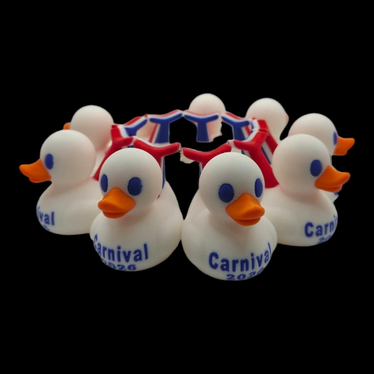 Circular arrangement of white Carnival-inspired 3D printed ducks with orange beaks and red-and-blue whale tails. - JM Designs