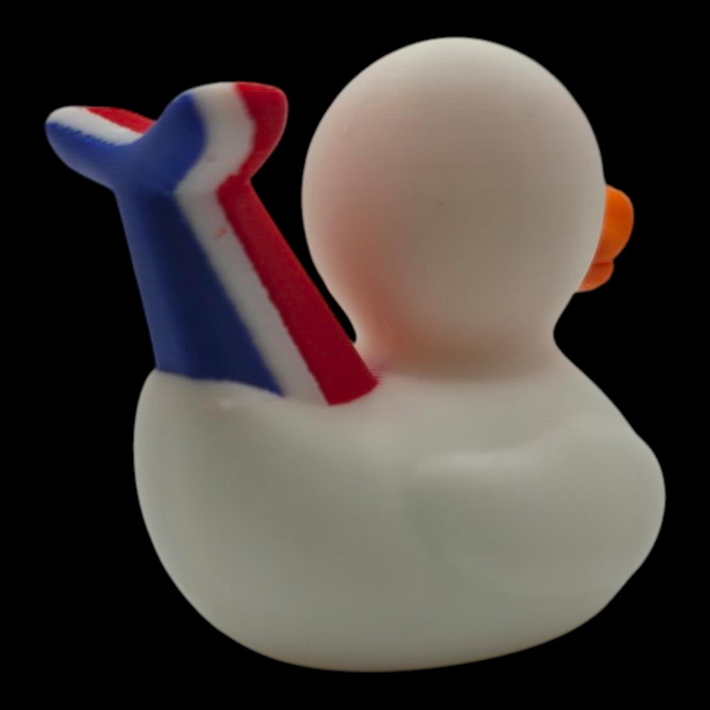 Rear right view of a white 3D printed cruise duck with an orange beak and raised red-and-blue whale tail. - JM Designs