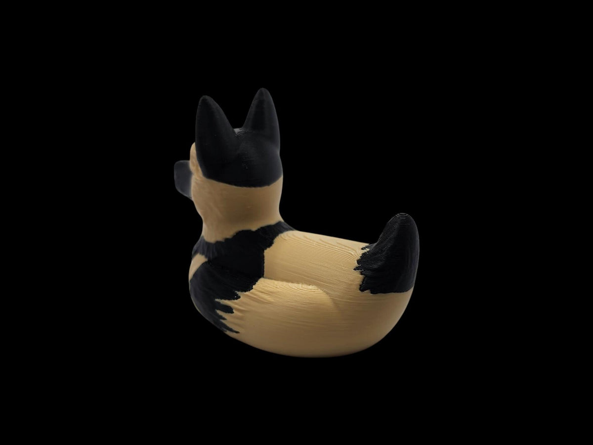Rear three-quarter view of a black and tan 3D printed German Shepherd duck with its tail on the right. - JM Designs