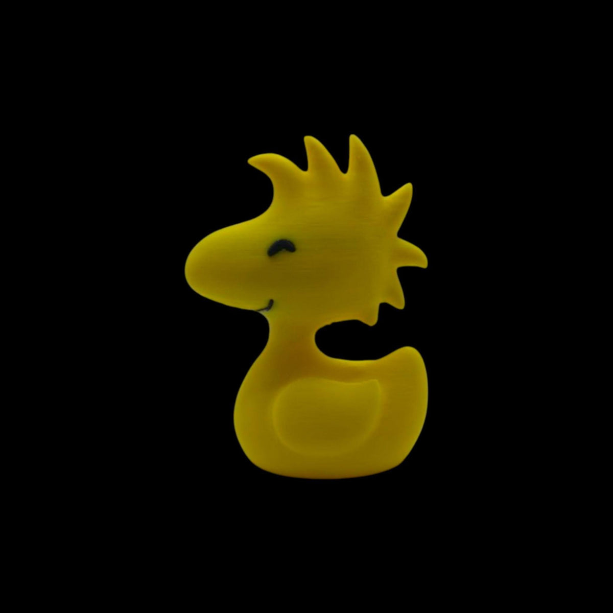 A yellow figurine of Woodstock from Peanuts, with spiky head feathers, a small beak, and two black dots for eyes