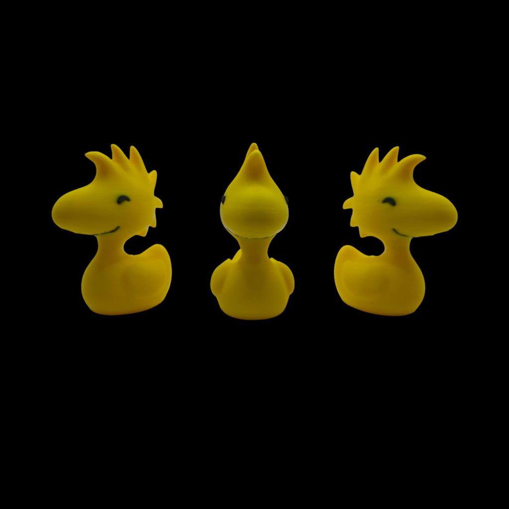 Three yellow Woodstock duck figurines are shown from slightly different angles, with the center one facing